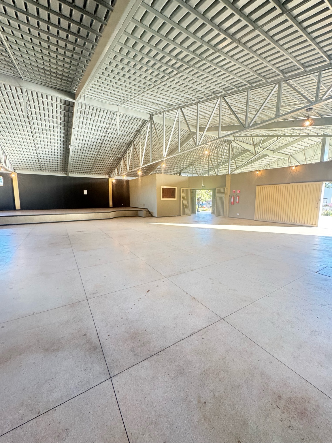 Salão de eventos amplo com palco no Clube Liberty